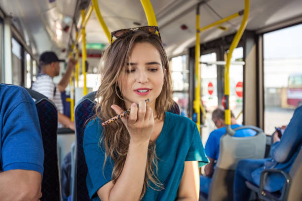 eine frau nimmt im bus beim pendeln eine sprachnachricht auf