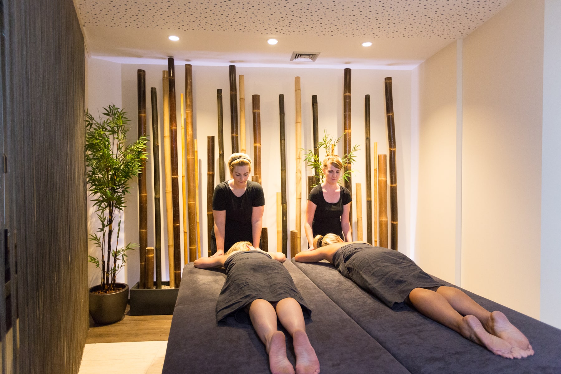 Zwei Damen massieren Gäste auf einer Liege