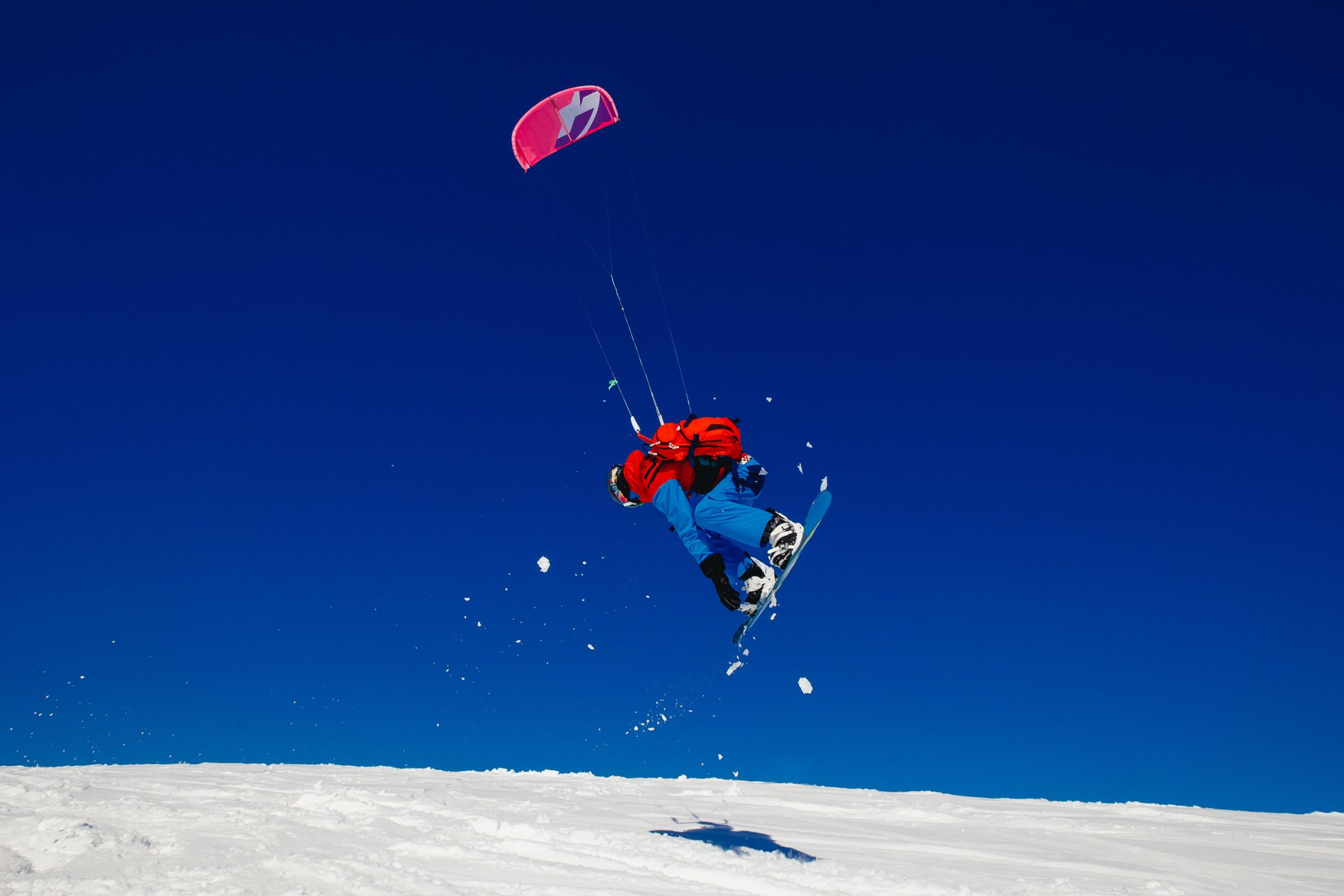 mann beim snowkiten auf einem hügel