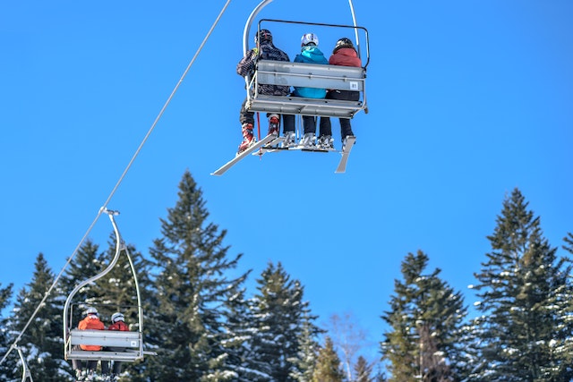 Drei Personen werden mit einem Skilift befördert, der sie zum ski fahren bringt