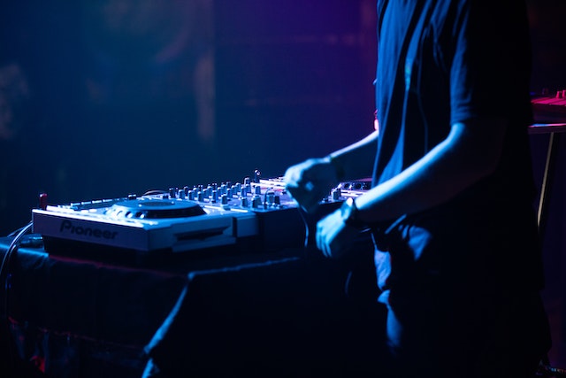 Ein DJ steht hinter seinem DJ-Pult