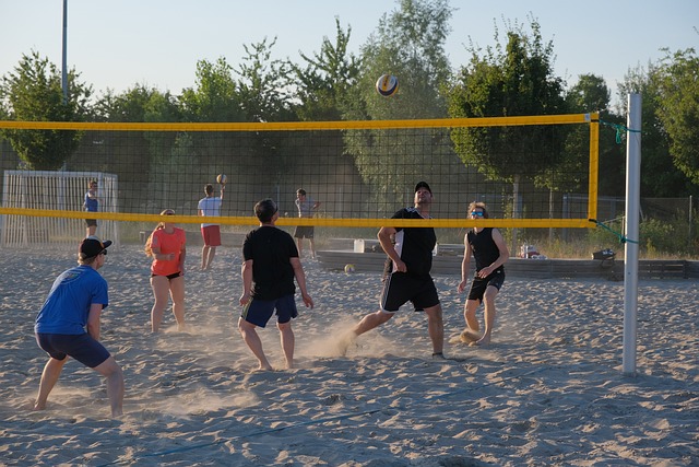 Eine Gruppe spielt Beachvolleyball am Strand an einem Badesee