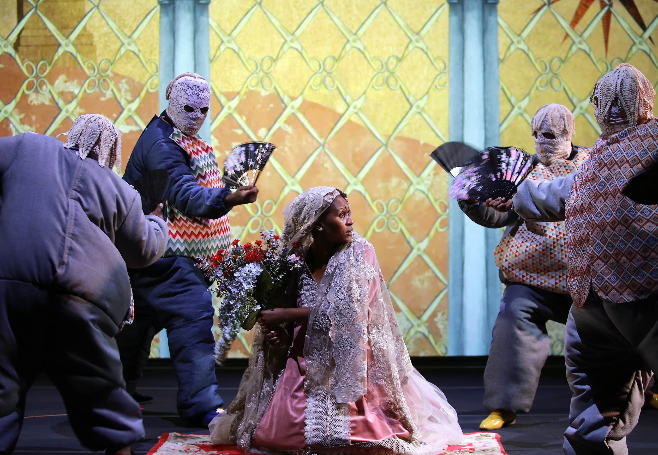 Maskierte Tänzer:innen auf einer Bühne