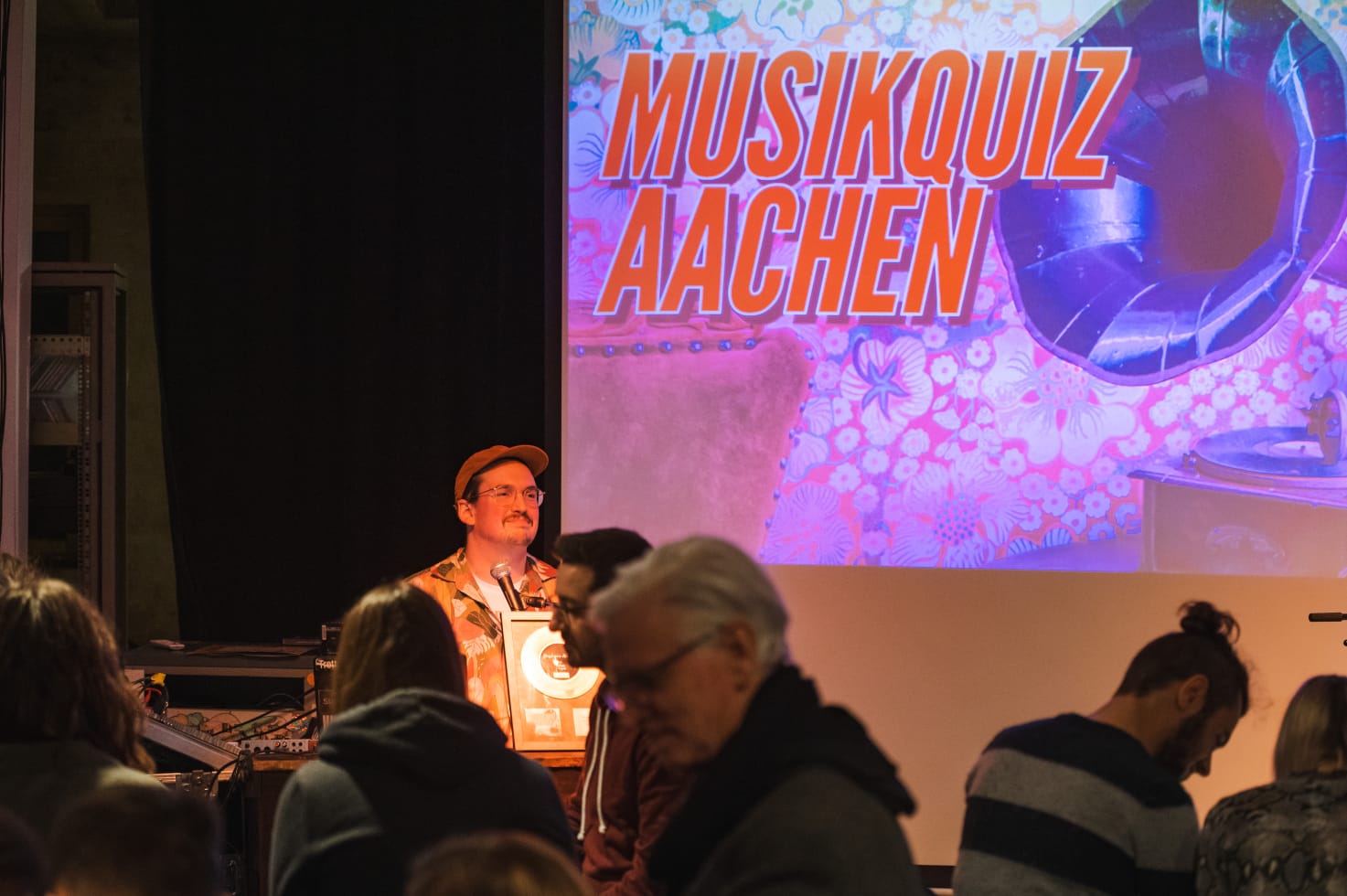 Moderator und Publikum des Musik Quiz Aachen