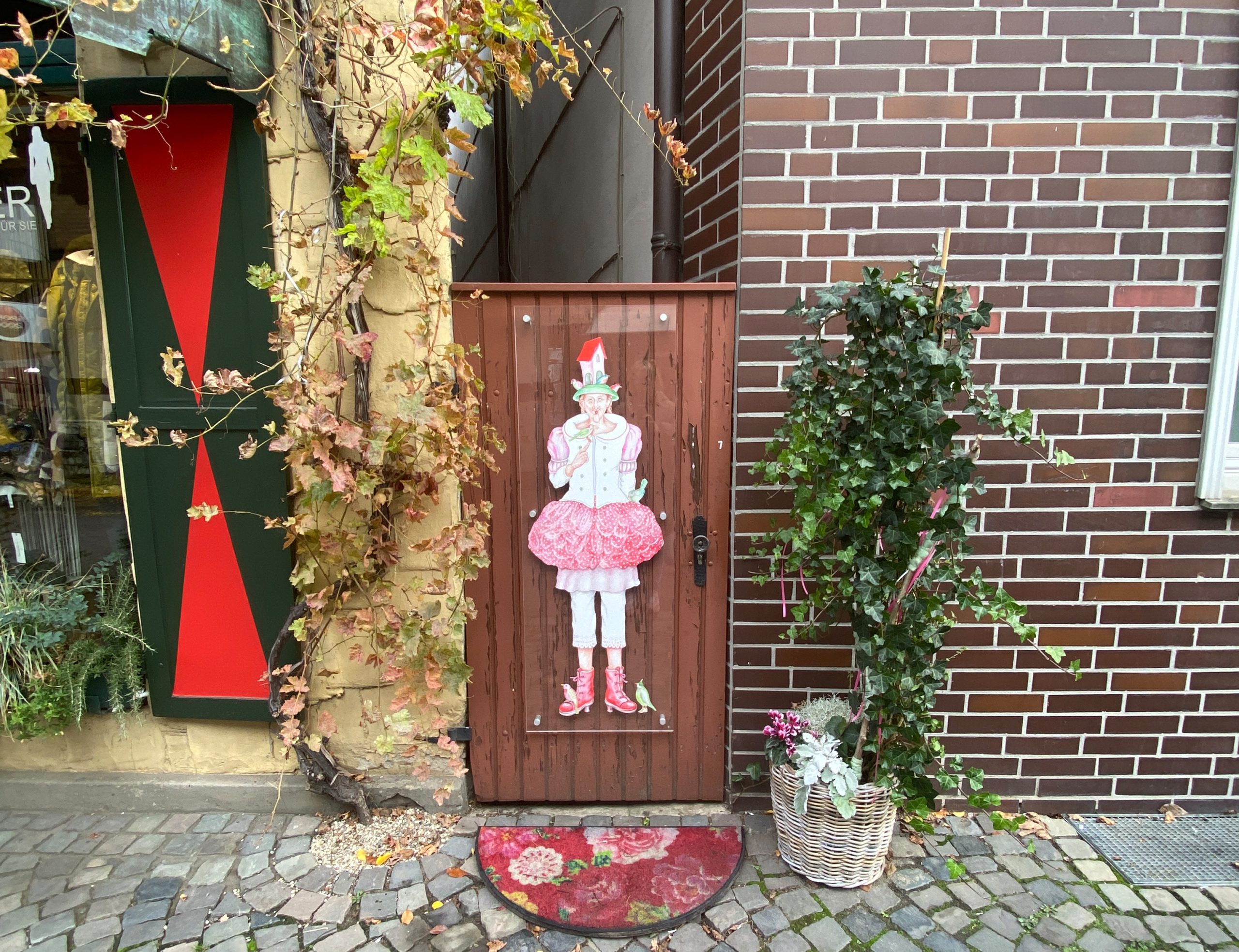 Eine mit einer Frauenfigur cartoonhaft bemalte Traufentür in Telgte