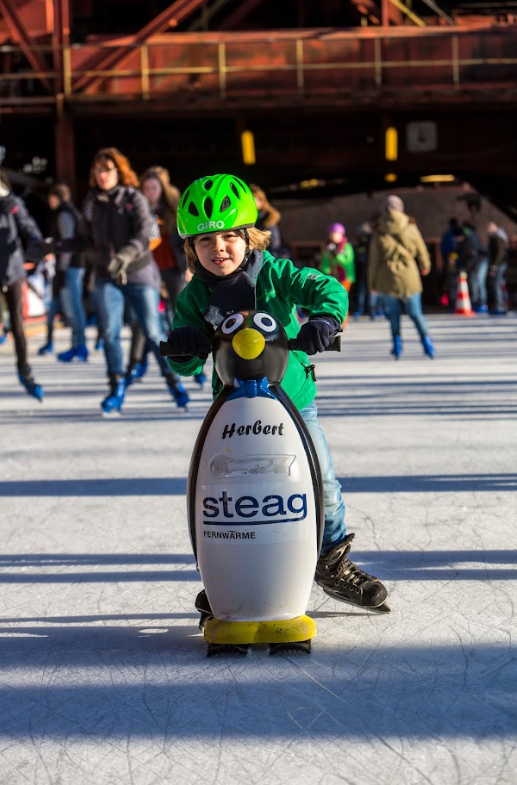 Kind mit Laufhilfe auf dem Eis