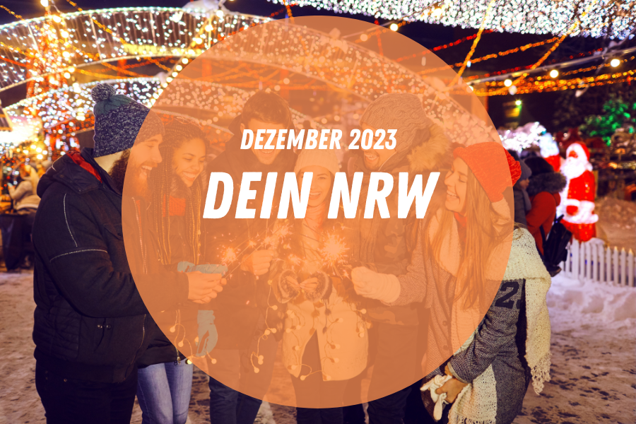 Eine Gruppe von Weihnachtsmarktbesucher:innen zündet Wunderkerzen an