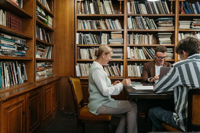 Zwei Menschen arbeiten in einer Bibliothek am Laptop