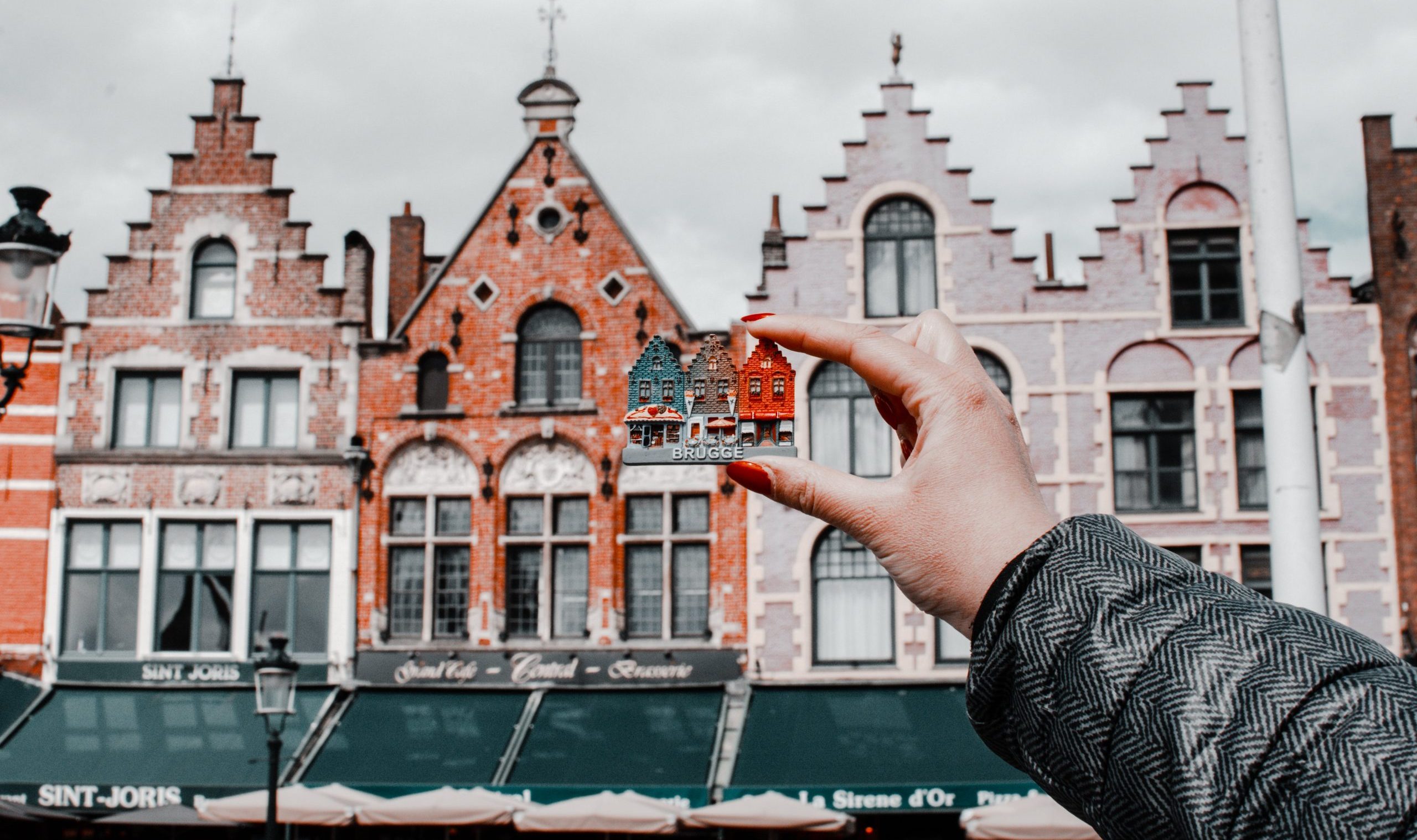 Hand hält Magneten vor einer Häuserreihe
