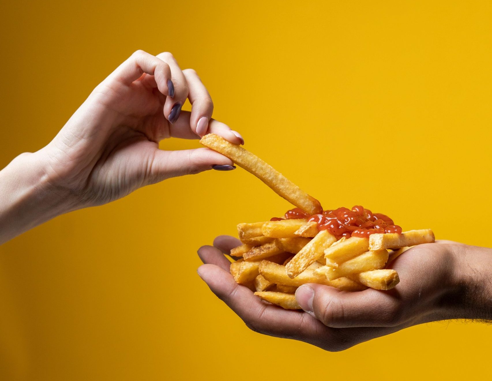 Hände mit Pommes frites