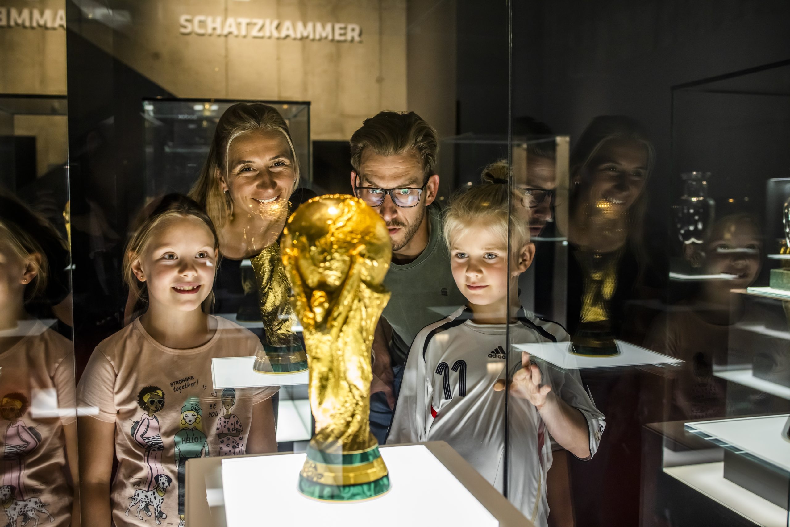 Familie betrachtet den Pokal der Fußball-WM 2014 im deutschen Fußball-Museum