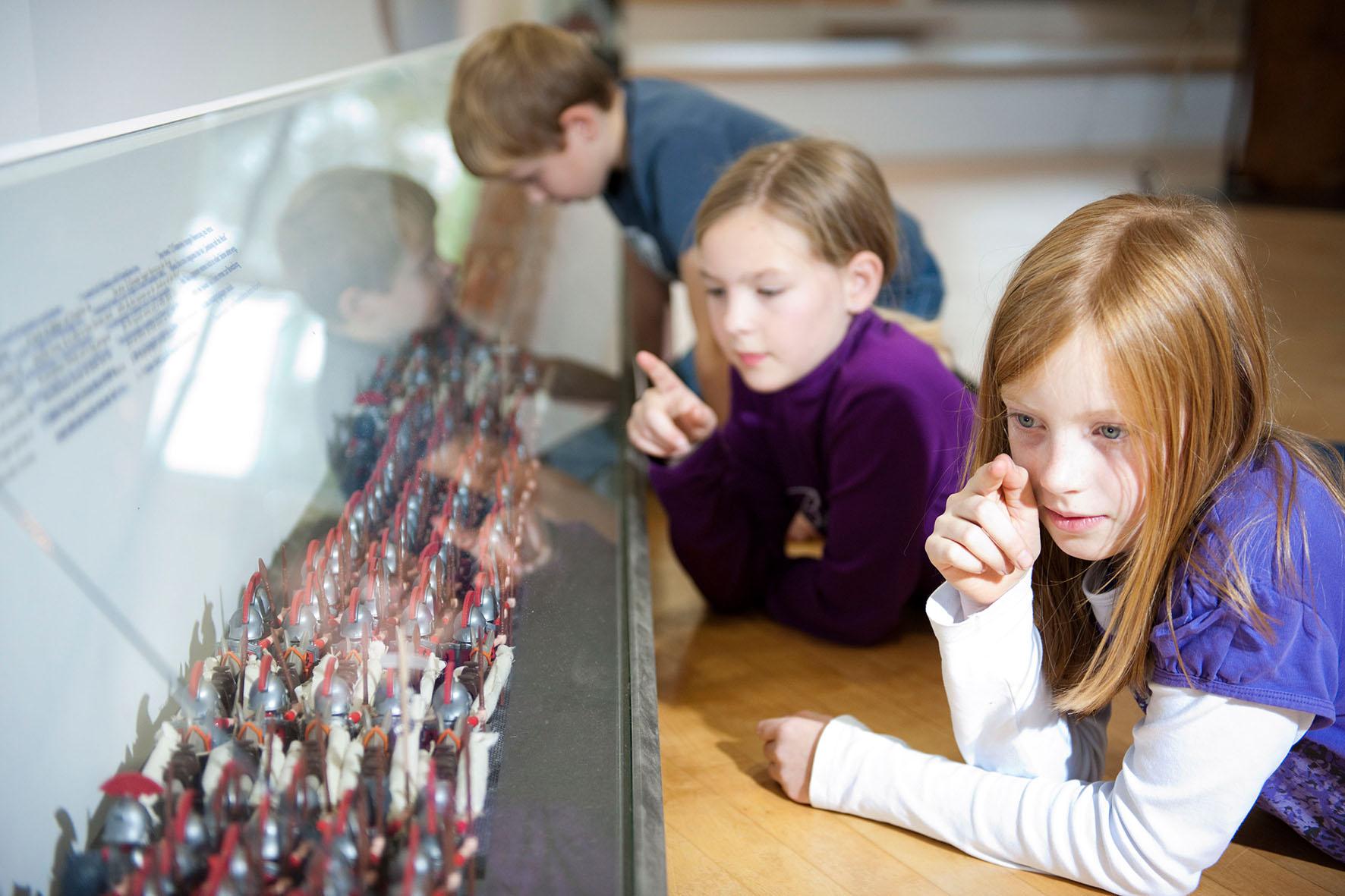 Kinder betrachten Legionärsfiguren