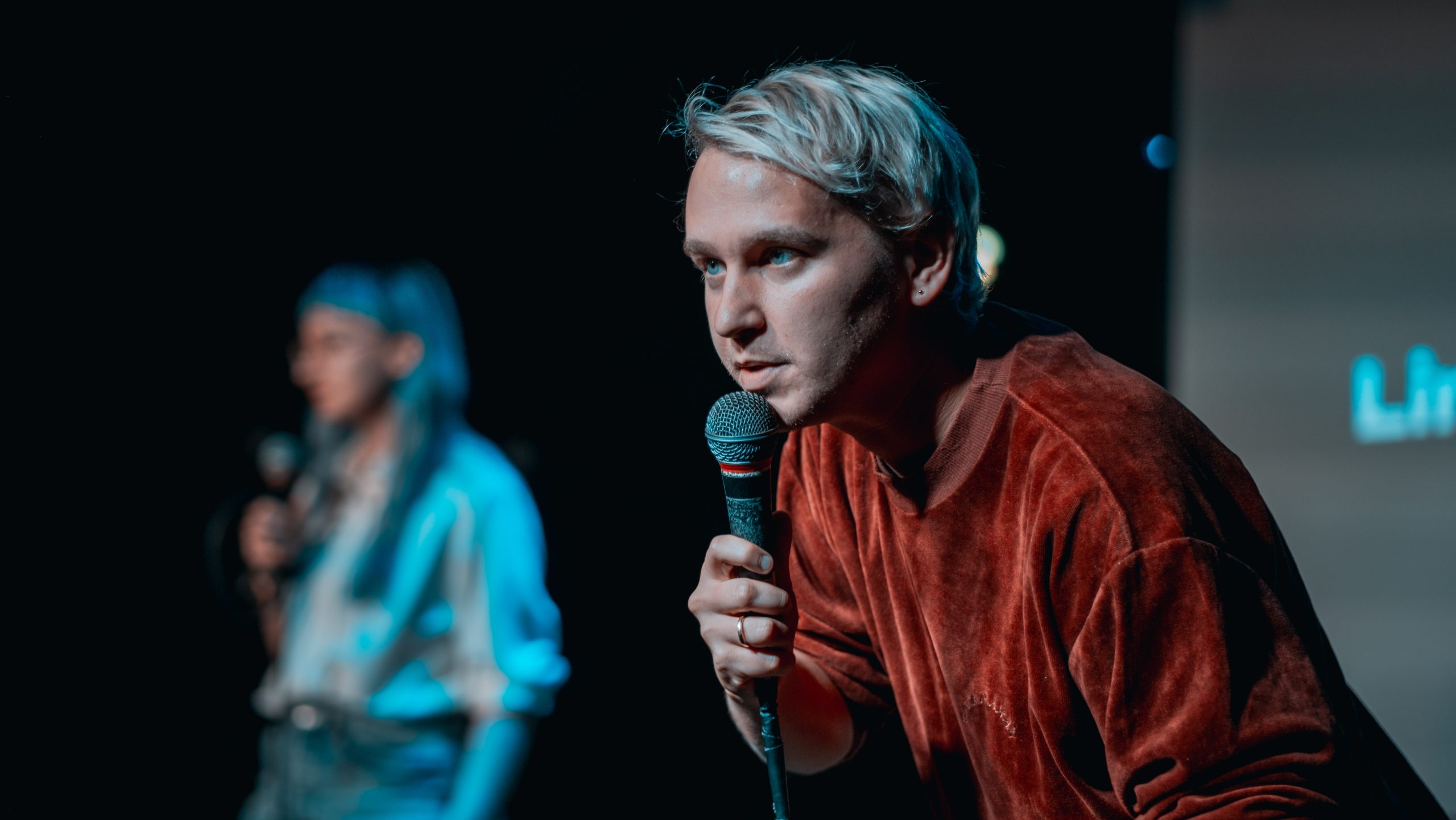 Slam-Moderator Yannick Steinkellner mit Mikrofon auf der Bühne