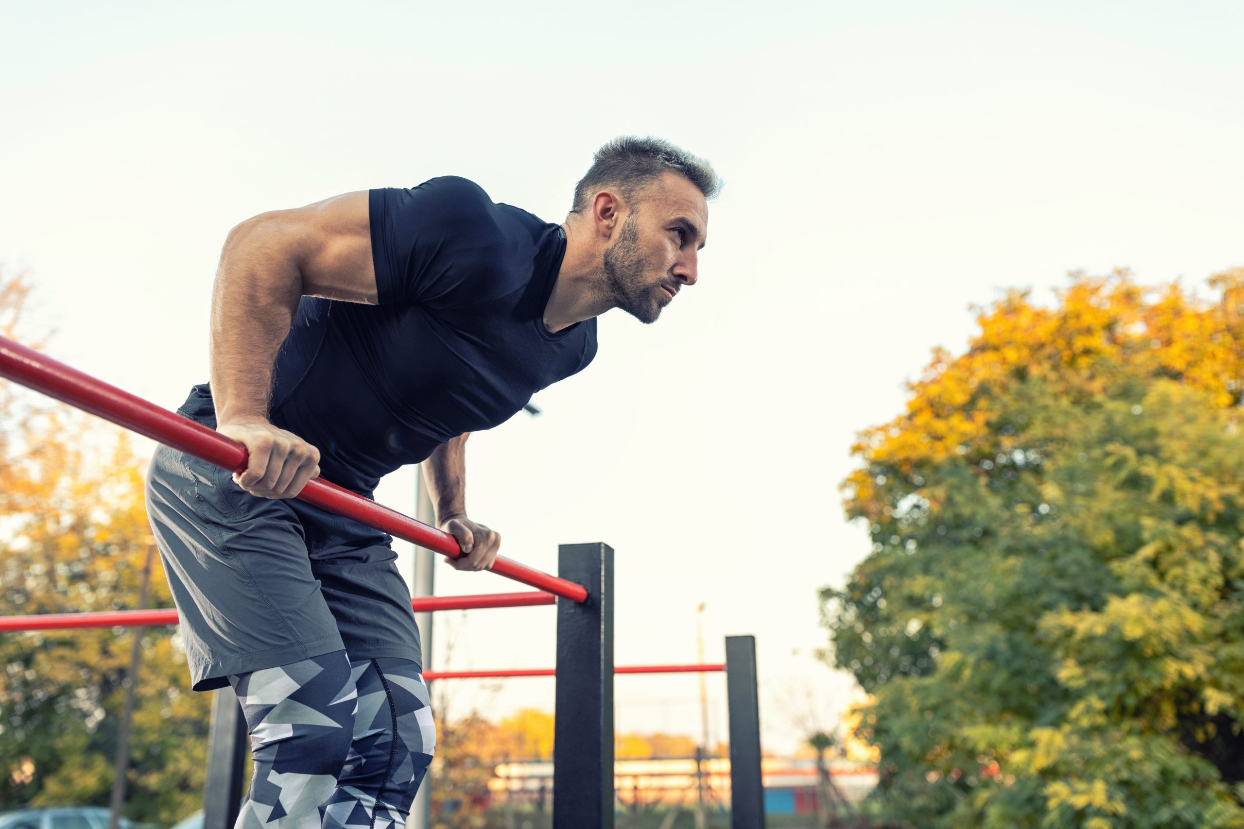 Ein Mann macht einen Muscle-Up in einem Calisthenics Park.