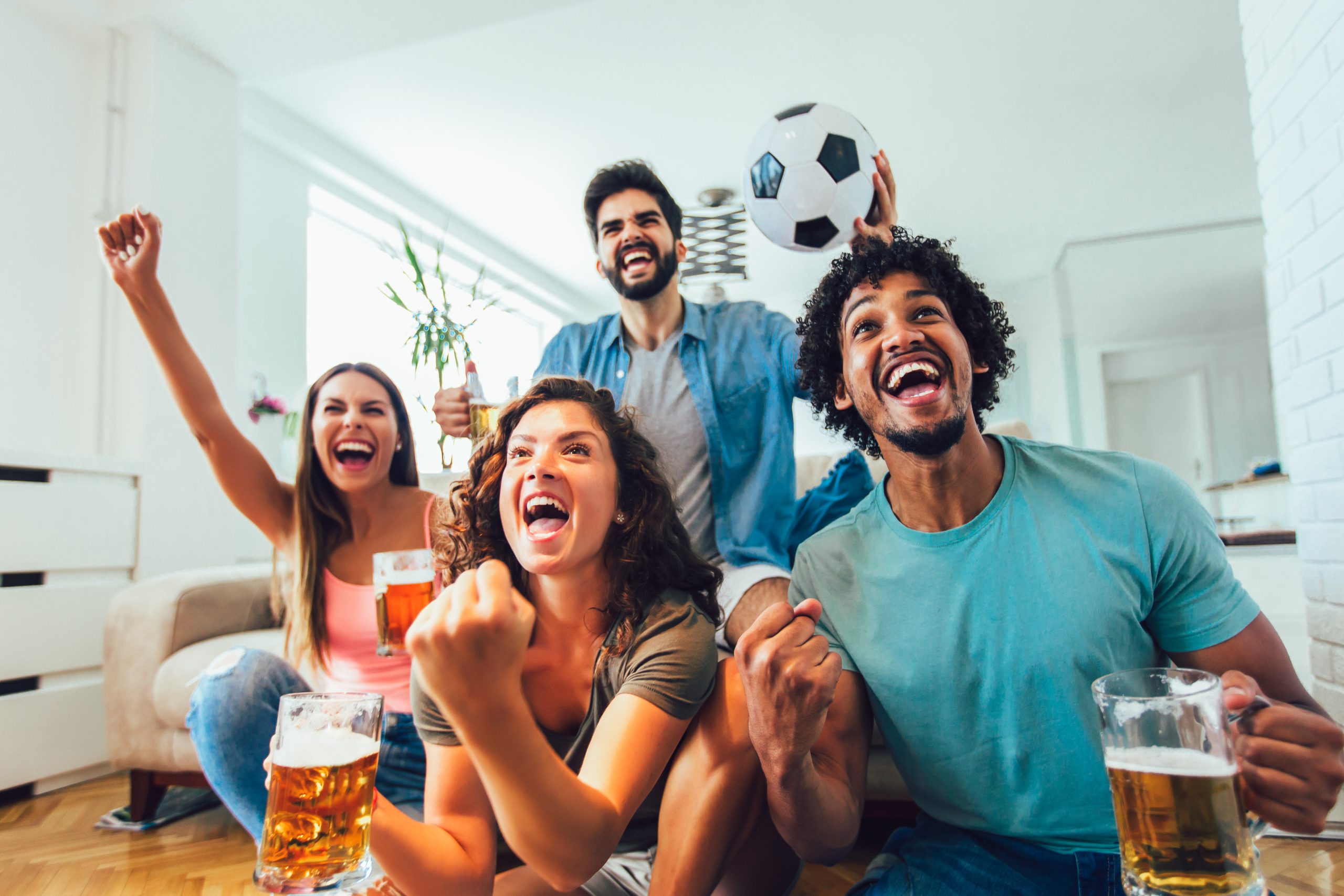 Fußball-Fans gucken ein Spiel zuhause auf dem Fernseher