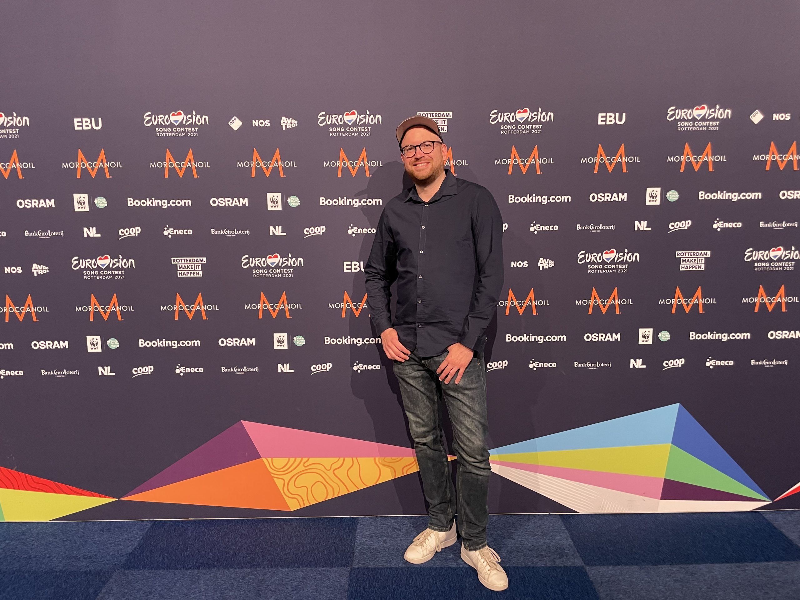 benni vor einer promo wand beim eurovision song contest