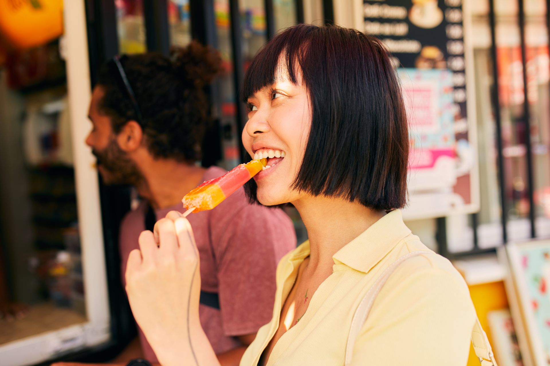 Eine Frau isst ein Eis an einem Kiosk,