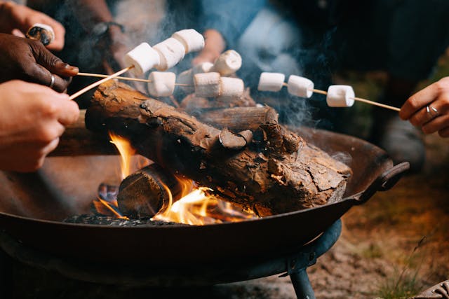 Marshmallows werden über einen Grill gehalten