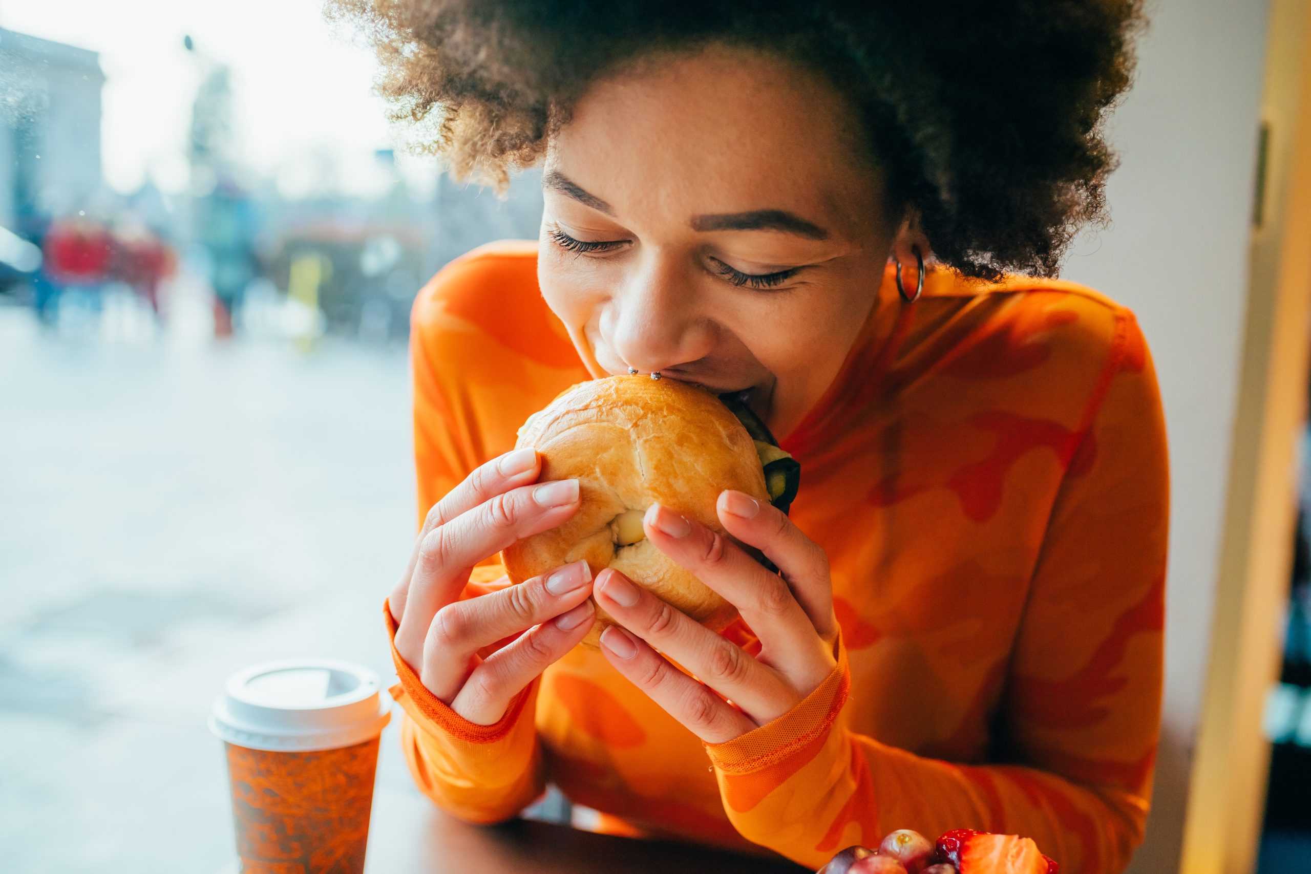 Junge Frau, die einen Burger isst