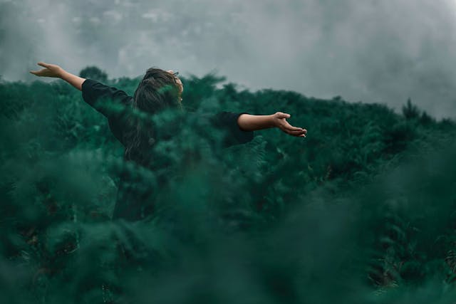 Mann in der Natur, breitet die Arme aus