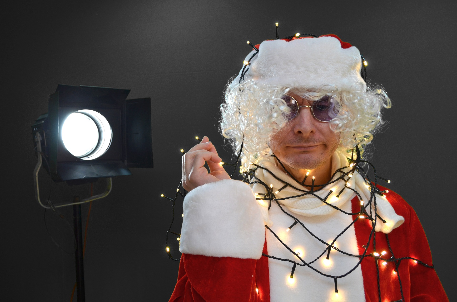 Mann im Weihnachtsmann-Kostüm und mit Lichertekette
